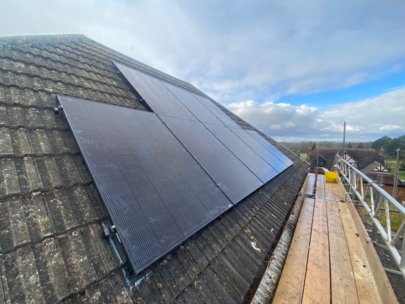 Black solar panels neatly installed on a grey tiled roof