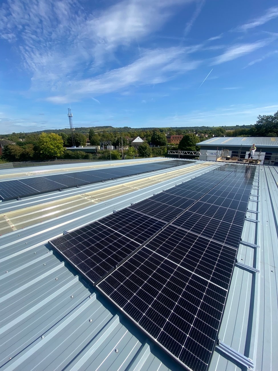 Commercial rooftop solar installation under a clear blue sky