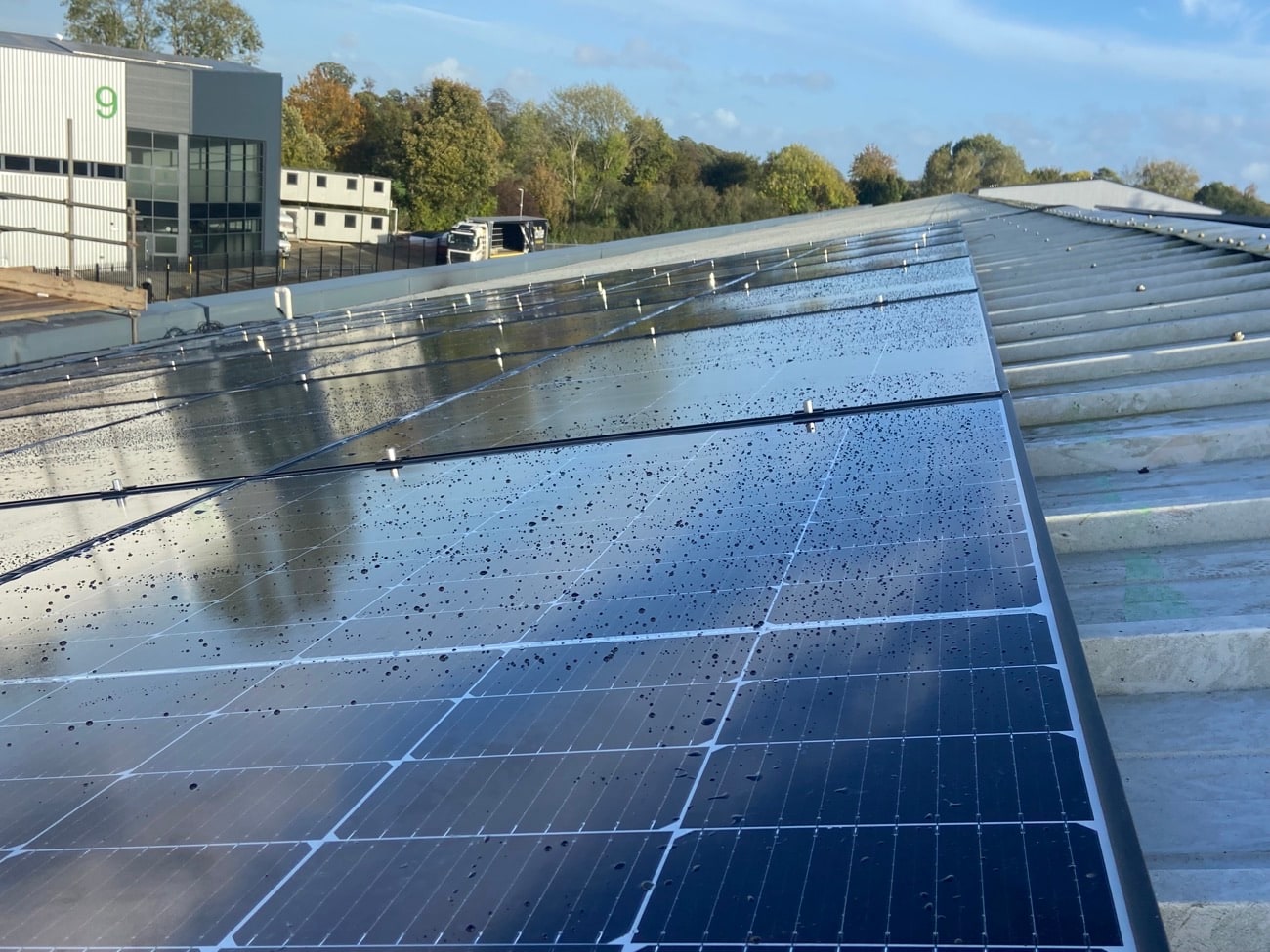 Commercial solar array on a metal roof beside a business unit