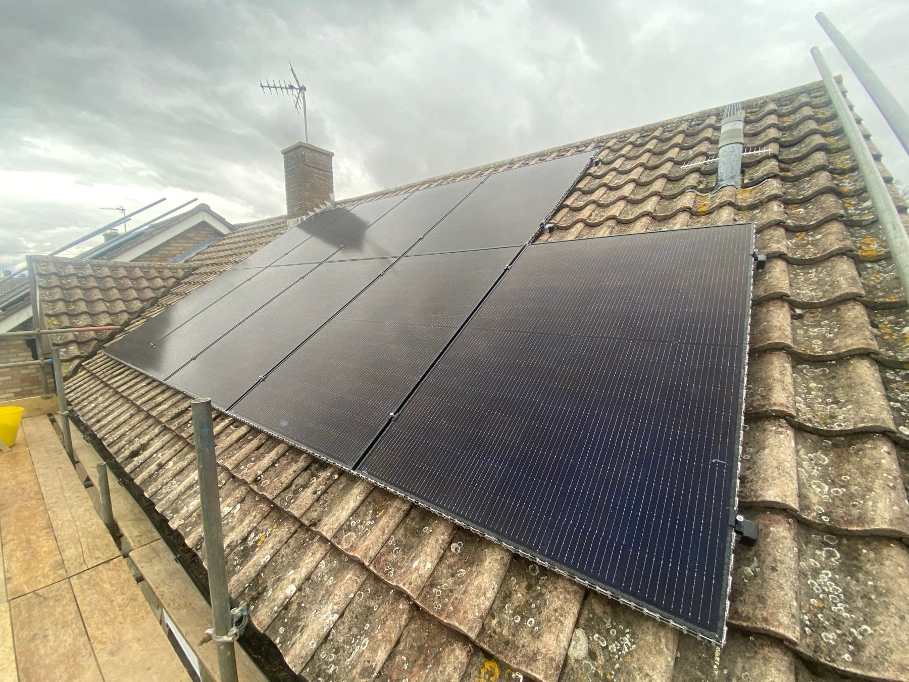 All-black solar panels installed on a red tiled roof