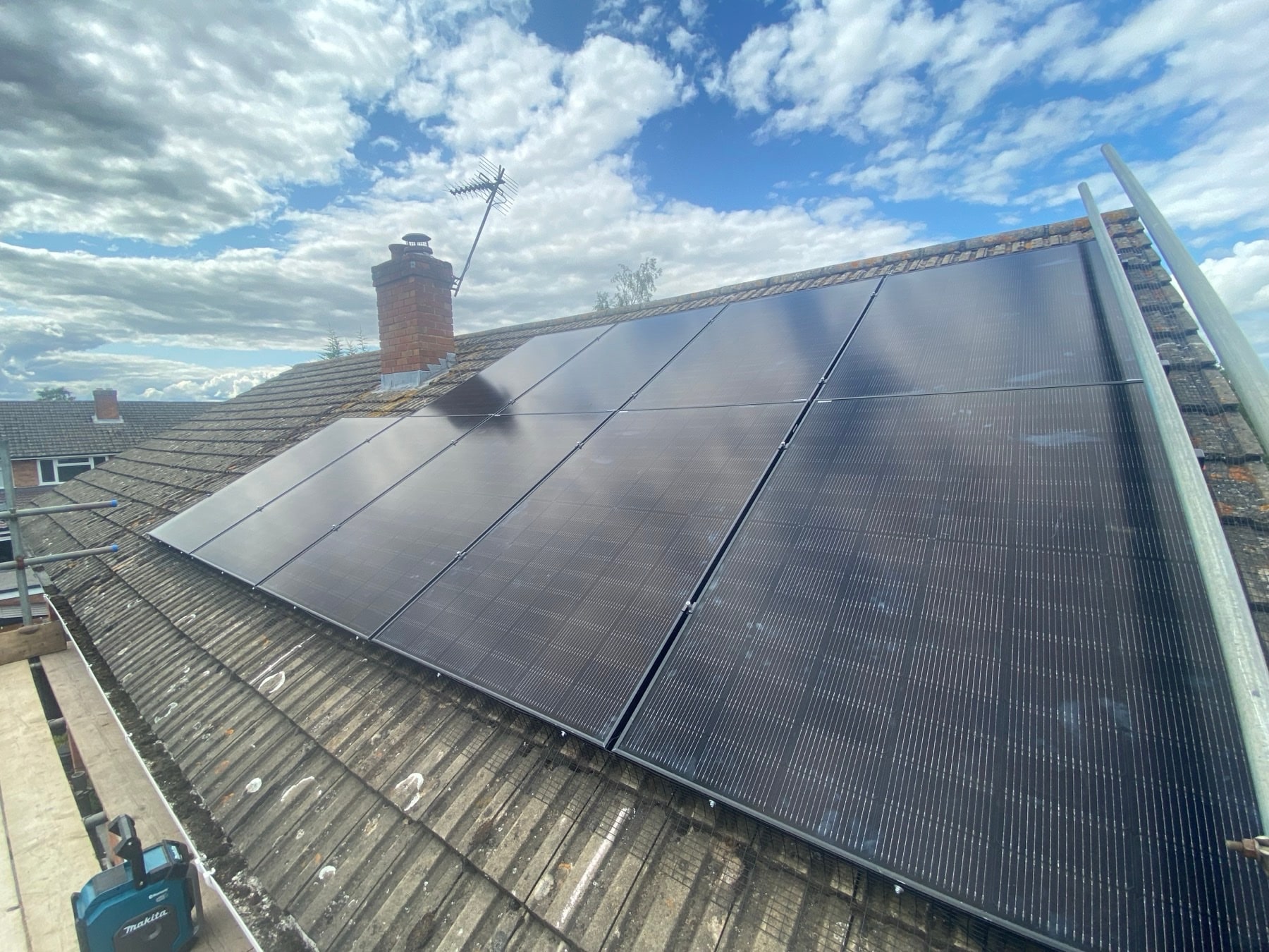Full row of all-black solar panels on a red tiled roof