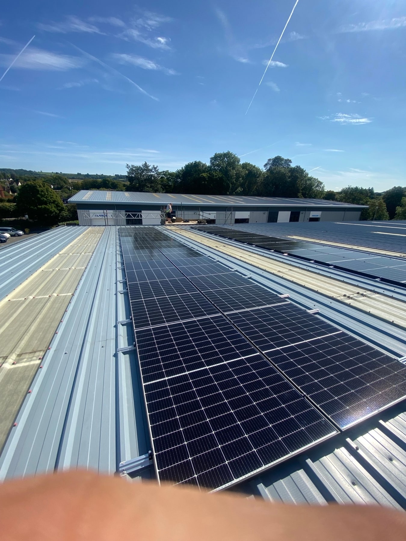 Solar panels on a commercial metal roof overlooking business units